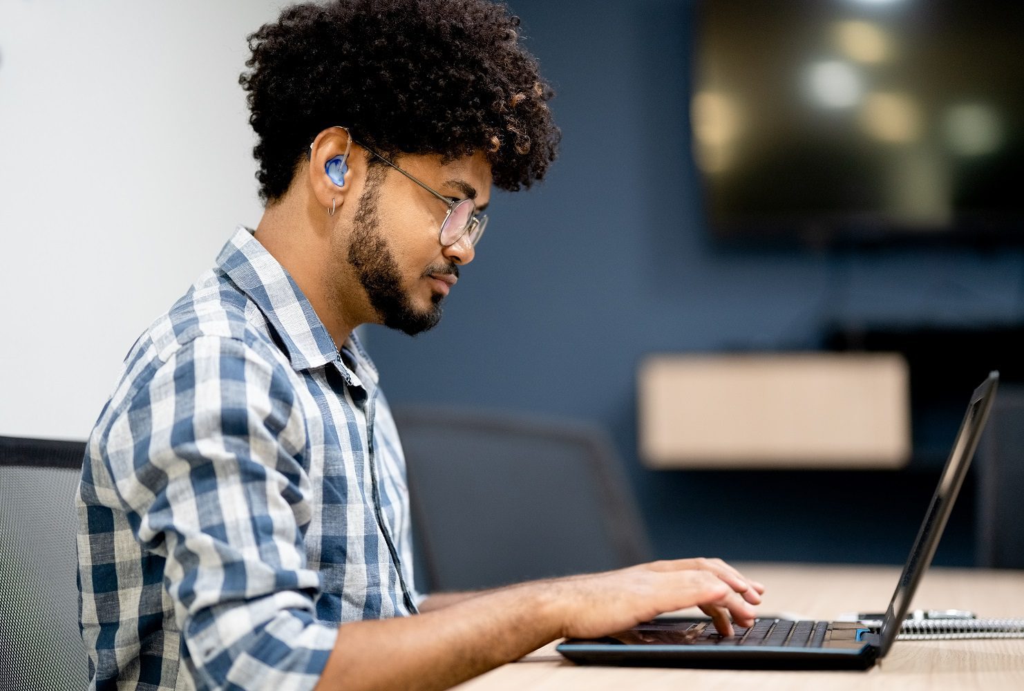 Confident, hearing-impaired man working on laptop testing app UX